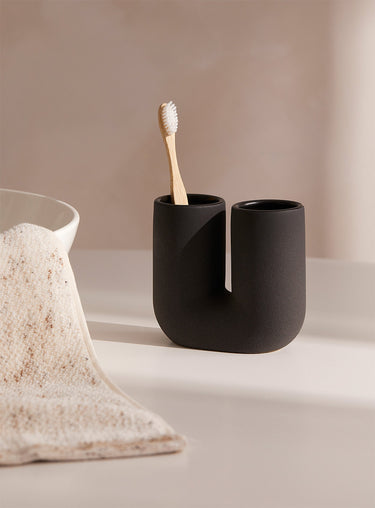Black cylindrical toothbrush holder